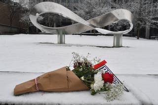 A bouquet of flowers, containing a pennant flag, laid in the snow at Brown